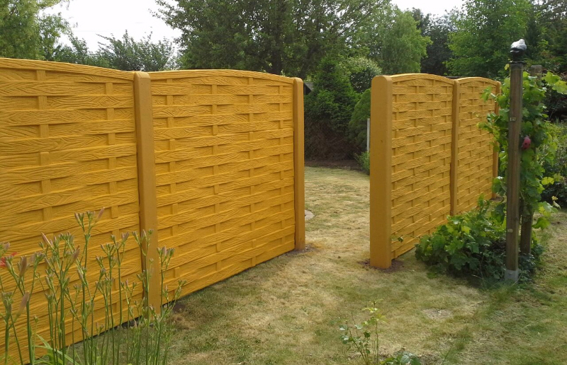 Clôture béton 3D motif tressé doré dans jardin